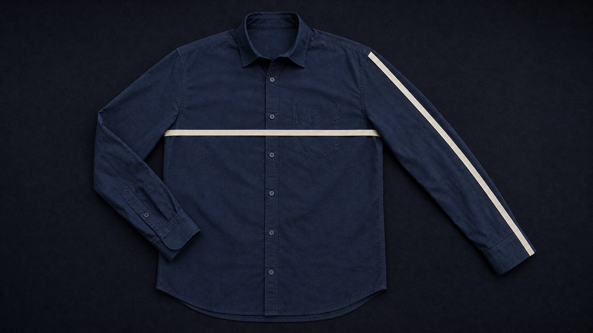 A shirt laid flat with a measuring tape across the chest and along the sleeve